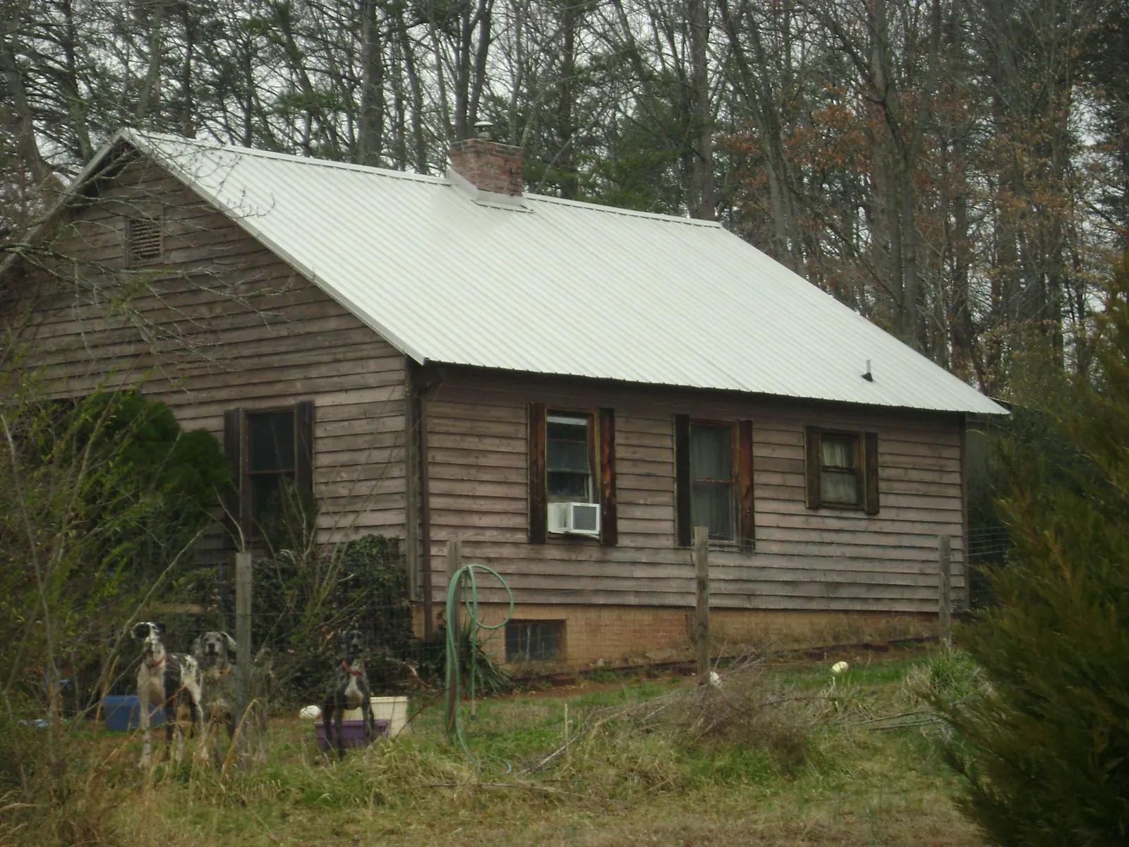 White metal roof on an old wood sided farmhouse, from a Metal Roof Installation job in Kellogg